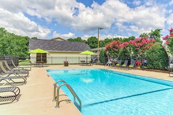 A swimming pool with a yellow building in the background.